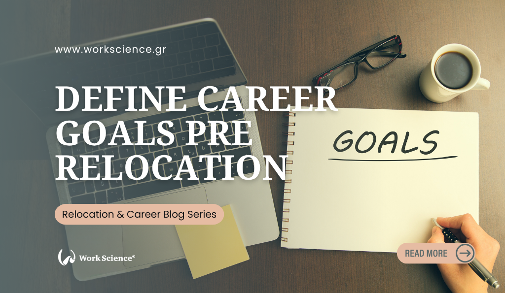 An overhead view of a desk where a person is writing the word "GOALS" in a notebook next to a laptop and coffee, symbolizing the critical step of defining career objectives before moving to a new location.