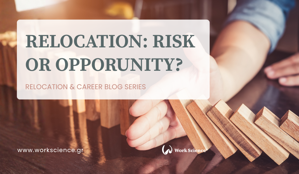 The image features a close-up of a person's hand, dressed in a blue shirt, trying to stop a chain reaction of falling wooden dominoes on a dark wooden table.