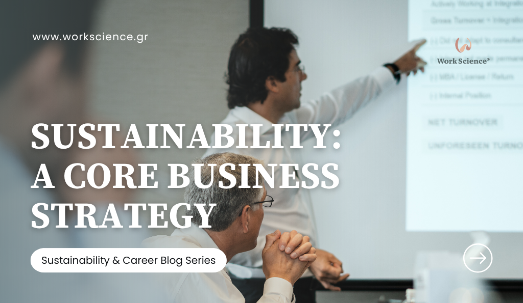 Two business professionals are in a meeting, with one man pointing toward a large projected screen showing financial figures and business points, illustrating the integration of sustainability into core corporate strategy.