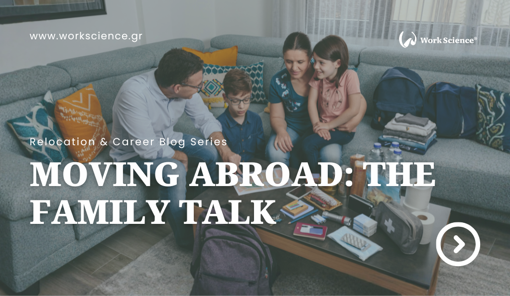 A family sitting together on a couch, discussing a possible move abroad with travel items spread on the table in front of them.
